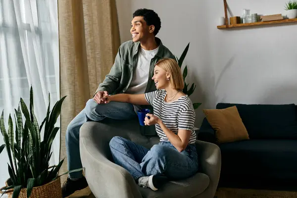 A young multicultural couple relaxes in their modern apartment, enjoying each others company. — Stock Photo