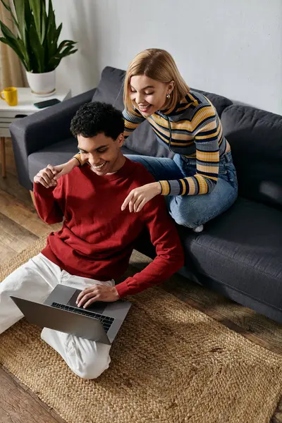 A happy multicultural couple spends quality time together in their modern apartment, using a laptop. — Stock Photo