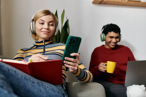A happy, multicultural couple enjoys a relaxing afternoon at home, using technology and connecting with each other. — Stock Photo
