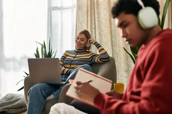 A happy multicultural couple enjoys a quiet moment together in their modern apartment, woman using laptop — Stock Photo