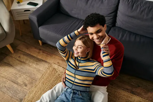 A happy multicultural couple relaxes on the floor of their apartment, enjoying quality time together. — Stock Photo