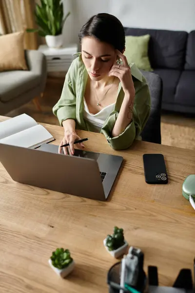 Une femme travaille dur à son bureau à domicile, concentrée et productive toute la journée. — Photo de stock