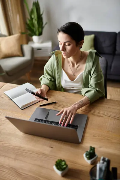 A woman works from home on her laptop and phone. — Stock Photo