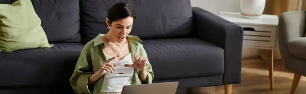 A woman working from home looks surprised while using her laptop. — Stock Photo