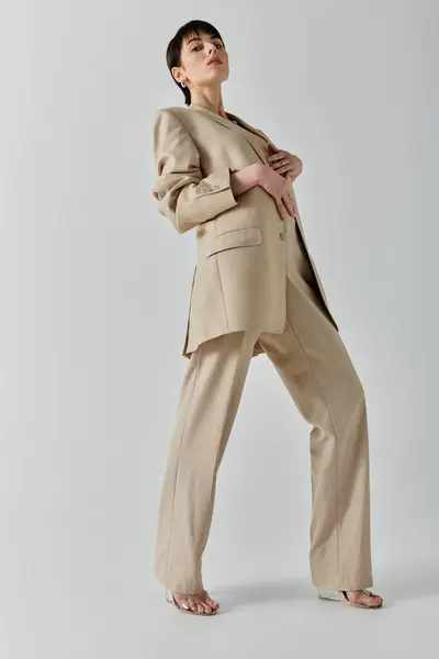 Eine Frau im hellbraunen Anzug posiert mit selbstbewusster Miene. — Stockfoto