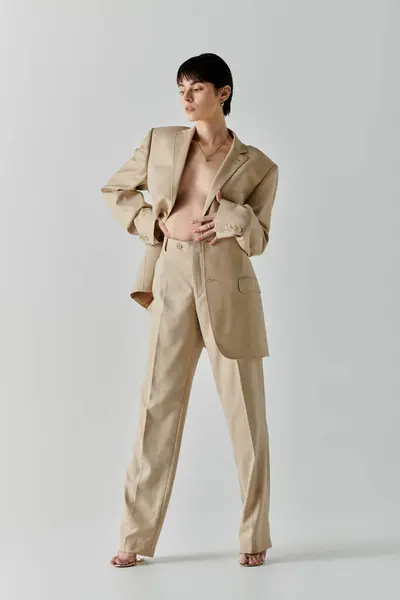 A woman in a tan suit poses confidently with a subtle air of mystery. — Stock Photo