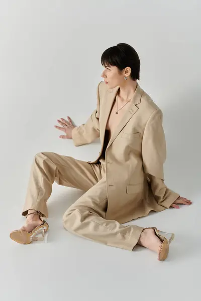 A woman poses in a tan suit, her gaze directed to the side. — Stock Photo