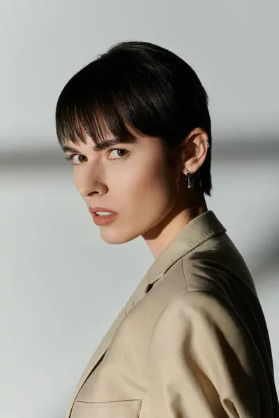 A portrait of a woman with short black hair, wearing a beige jacket. — Stock Photo