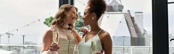 A lesbian couple celebrates their wedding with a toast on a rooftop terrace. — Stock Photo