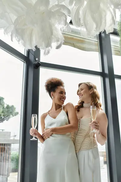 Two brides celebrate their wedding day with champagne, surrounded by elegant decor. — Stock Photo