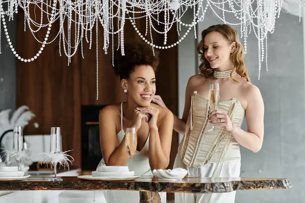 Two brides raise a glass to celebrate their love at their wedding reception. — Stock Photo