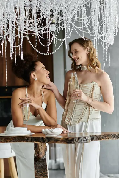 Two brides celebrate their wedding day with a glass of champagne. — Stock Photo