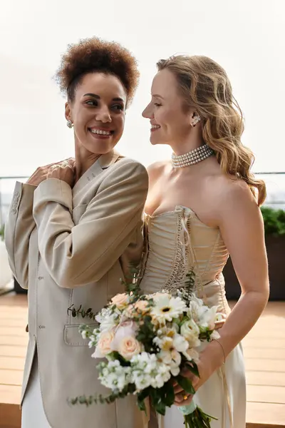 Una pareja de lesbianas comparte un momento cariñoso el día de su boda. - foto de stock