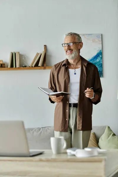 Ein reifer schwuler Mann mit Tätowierungen und grauen Haaren arbeitet fernab von zu Hause und präsentiert einen modernen Lebensstil und LGBTQ + -Repräsentation. — Stockfoto