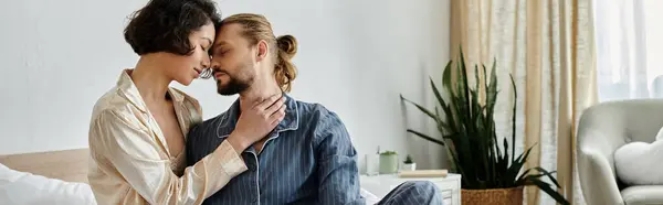 Una pareja cariñosa se acurruca en una cama en casa, disfrutando de un momento de relax juntos. - foto de stock