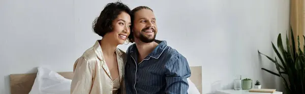 A loving couple in pajamas enjoys a quiet morning together, snuggling in bed. — Stock Photo