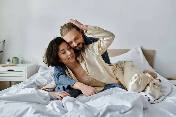 A couple cuddles and relaxes in bed, enjoying each others company. — Stock Photo