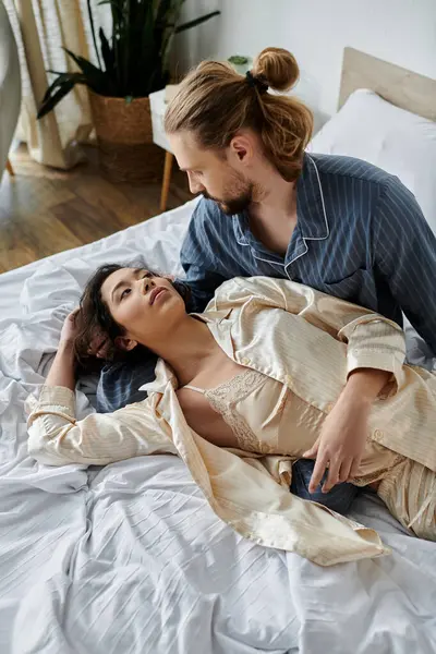 A young couple relaxing in bed, enjoying a moment of closeness and affection. — Stock Photo
