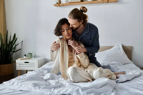 A loving couple cuddles on a bed, enjoying a relaxing moment together. — Stock Photo