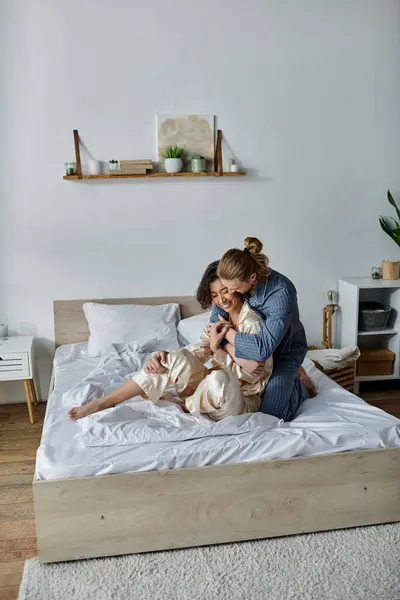 A loving couple cuddles and embraces on a bed, enjoying a moment of intimacy and relaxation. — Stock Photo
