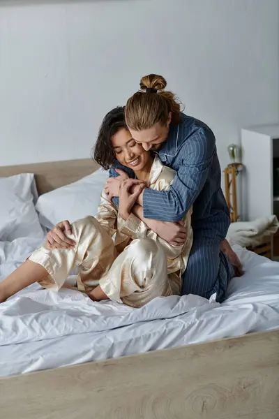 A loving couple hugs on a bed, expressing their affection for each other. — Stock Photo