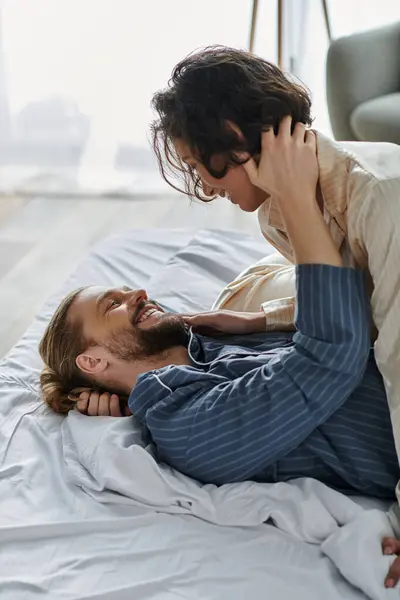 A couple lies in bed, embracing and sharing a loving moment together. — Stock Photo