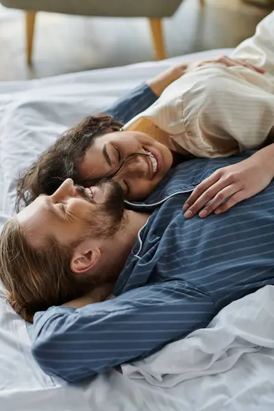 A loving couple cuddles in bed, enjoying a relaxing morning together. — Stock Photo