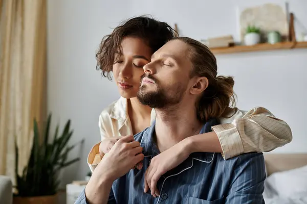 Una coppia si rilassa a casa, con la donna che abbraccia amorevolmente l'uomo da dietro. — Stock Photo