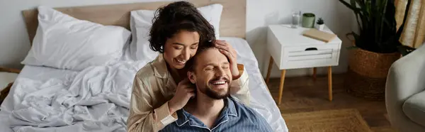 A couple laughs together while lying in bed on a sunny morning. — Stock Photo
