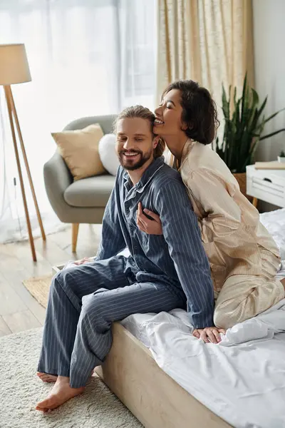 A loving couple relaxes on a bed at home, enjoying each others company. — Stock Photo