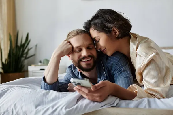 A loving couple spends a relaxing morning at home, cuddling in bed and enjoying each others company. — Stock Photo