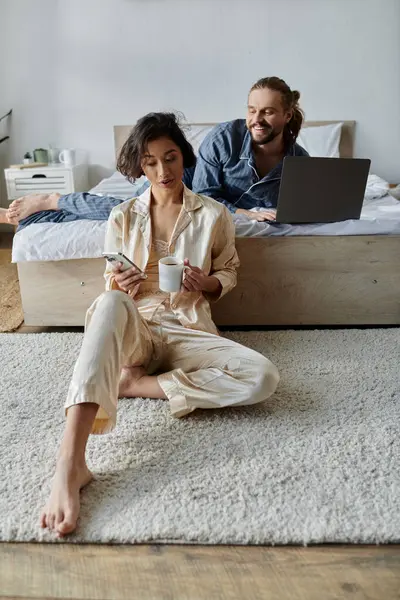 A loving couple spends their morning relaxing at home, enjoying coffee and each others company. — Stock Photo