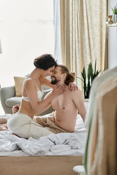 A couple cuddles on a bed, enjoying a moment of intimacy. — Stock Photo