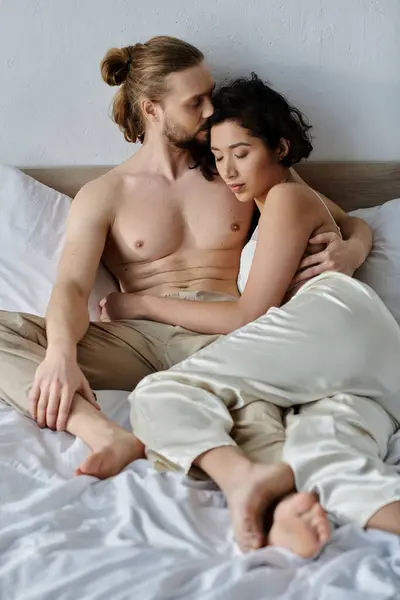 A loving couple cuddles in bed, enjoying a moment of intimacy. — Stock Photo