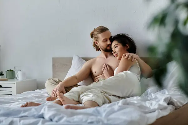 A couple cuddles and relaxes on a bed together, enjoying a peaceful moment in their home. — Stock Photo