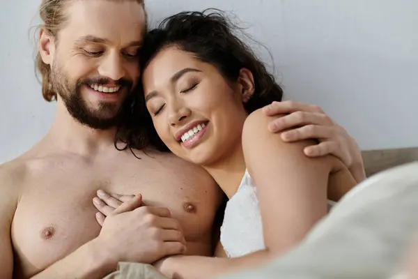 A man and woman share a loving embrace in bed, enjoying a peaceful morning together. — Stock Photo