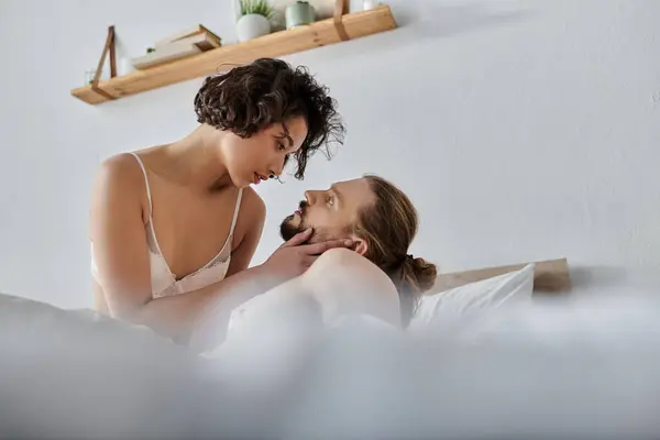 A loving couple shares a tender moment in bed, looking into each others eyes with affection. — Stock Photo