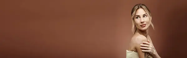Una giovane donna con la vitiligine posa con spalle nude su uno sfondo beige. — Foto stock