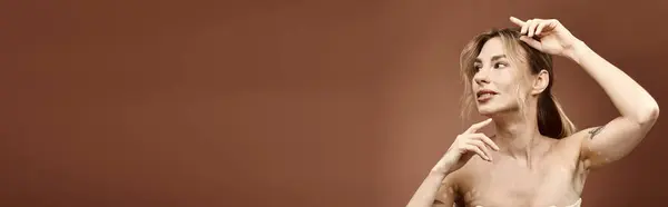 Una giovane donna con la vitiligine posa con le spalle nude su uno sfondo beige. — Foto stock