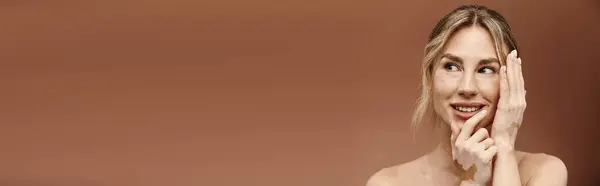 A young woman with vitiligo poses with her shoulders bare, displaying her unique beauty against a beige background. — Stock Photo