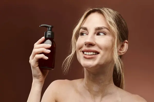 Uma jovem mulher com vitiligo detém um produto de cuidados com a pele com um sorriso, mostrando a beleza da pele diversificada. — Fotografia de Stock