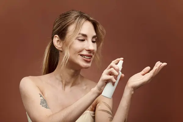 A young woman with vitiligo smiles as she applies skincare product to her hand. — Stock Photo