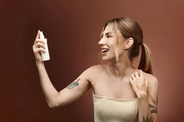 A young woman with vitiligo smiles as she applies skincare to her arm. — Stock Photo