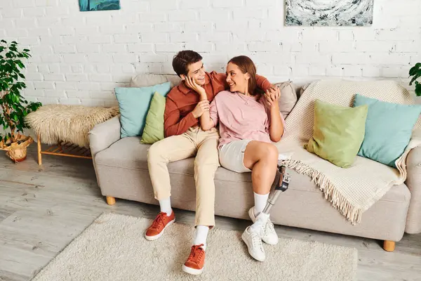 A couple relaxes on a couch, sharing a loving glance. — Stock Photo