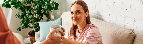 A woman with a prosthetic leg accepts a cup of coffee from her boyfriend, smiling warmly at him. — Stock Photo