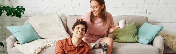 A woman with a prosthetic leg sits on a sofa with her boyfriend. — Stock Photo