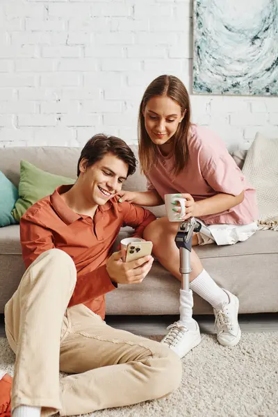 A couple relaxes on the floor, enjoying each others company. — Stock Photo