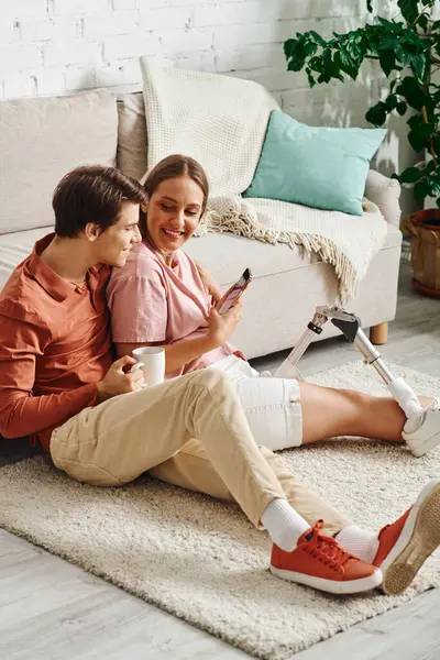 A young couple relaxes on a white rug, sharing a laugh and a moment of intimacy. — Stock Photo