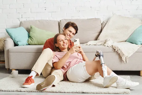 A young couple relaxes on the floor, enjoying each others company and a moment of shared laughter. — Stock Photo