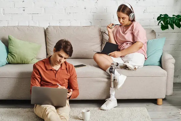 A couple spends time together, each working on their own tasks in a cozy living room. — Stock Photo